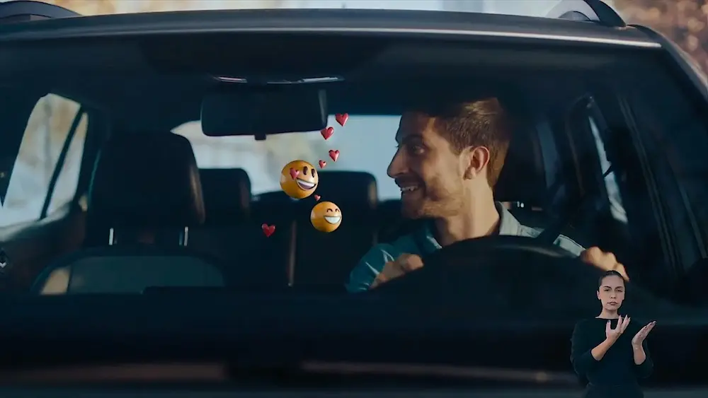 Homem dirigindo carro com emojis flutuantes.