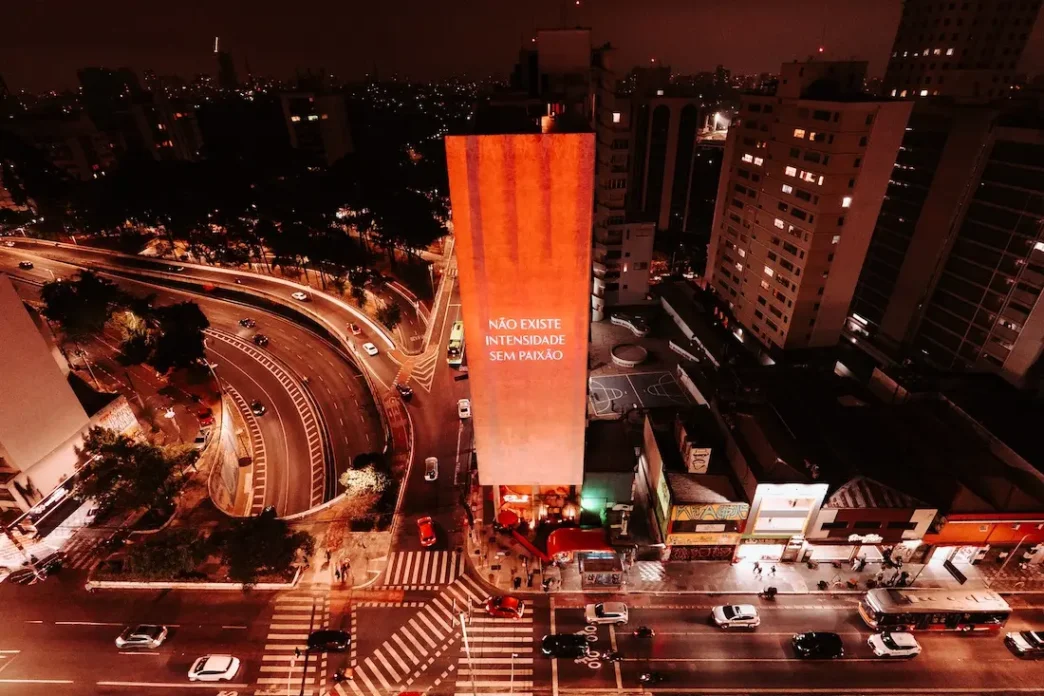 Prédio iluminado com frase motivacional à noite.