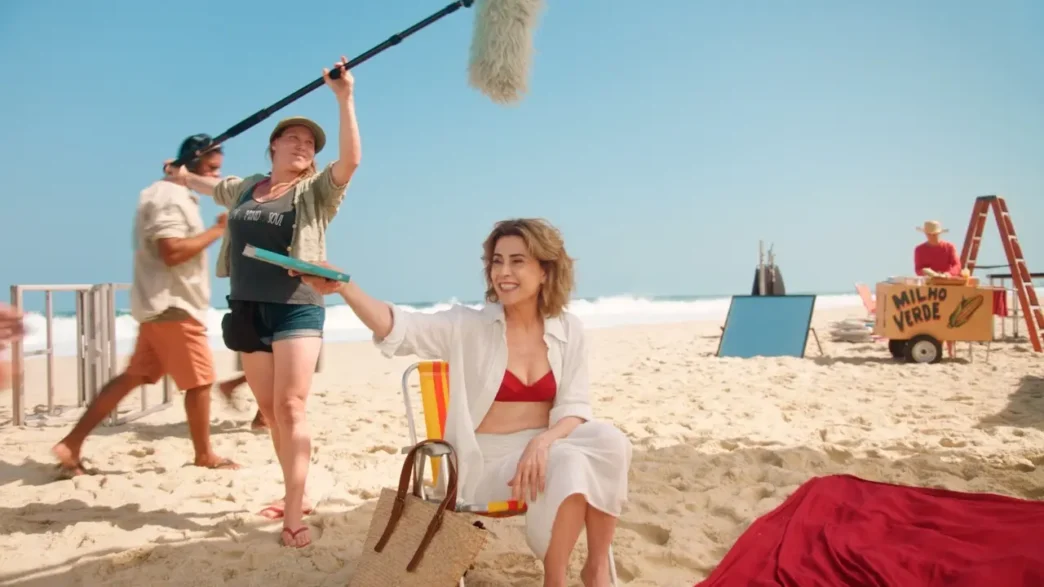 Filmagem em praia com equipe e atriz