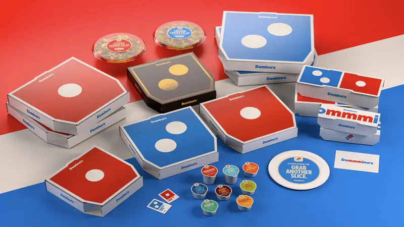 Caixas de pizza Domino's em várias cores.