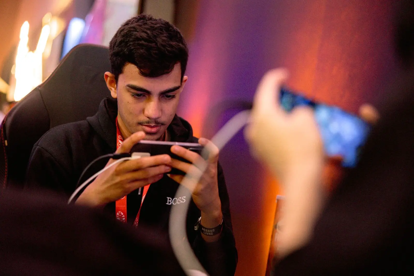 Pessoa jogando em smartphone durante competição.
