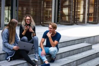 Estudantes conversando em escada ao ar livre.