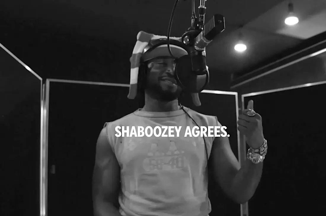 Homem grava música em estúdio com microfone.