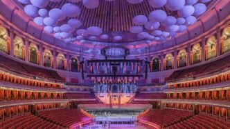 Interior de uma grande casa de shows iluminada.