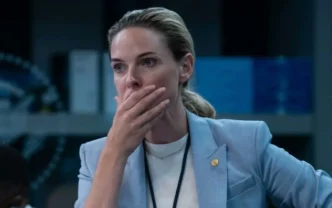 Pessoa surpresa, mão cobrindo a boca, roupa formal.