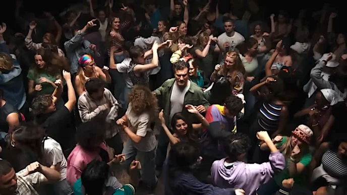 Pessoas dançando animadamente em festa movimentada.