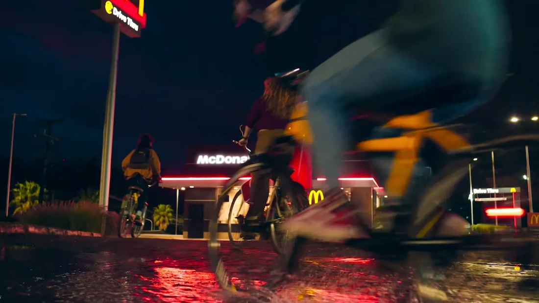 Ciclistas em frente a restaurante à noite.