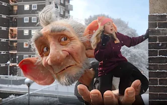 Gigante segura pessoa em ambiente urbano nevado.