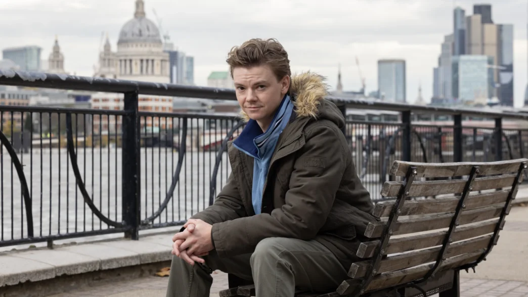 Homem sentado em banco, Londres ao fundo.