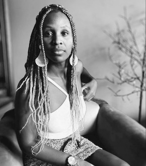 Mulher sentada em cadeira, preto e branco.