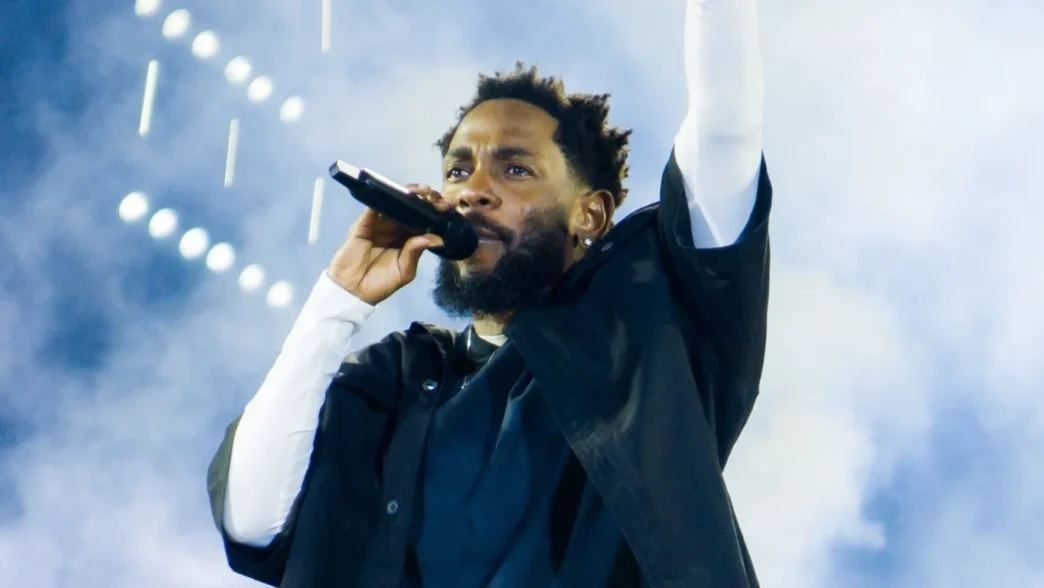 Cantor segurando microfone no palco.