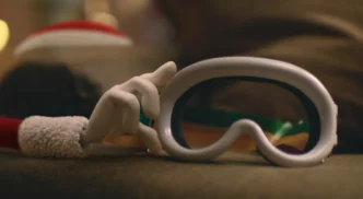 Mão segurando máscara de esqui branca.