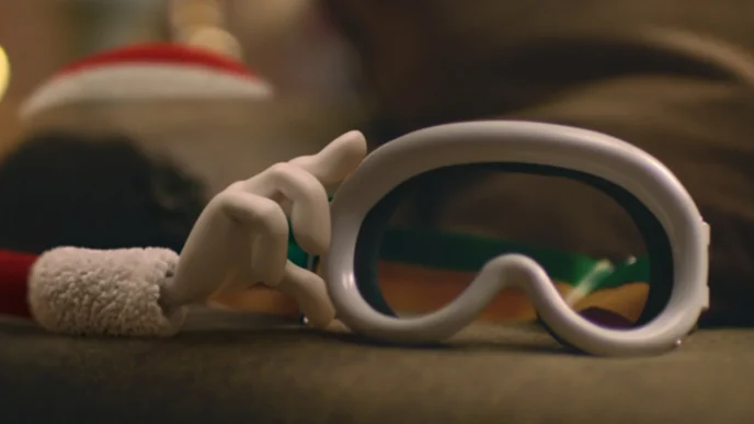 Mão segurando máscara de esqui branca.