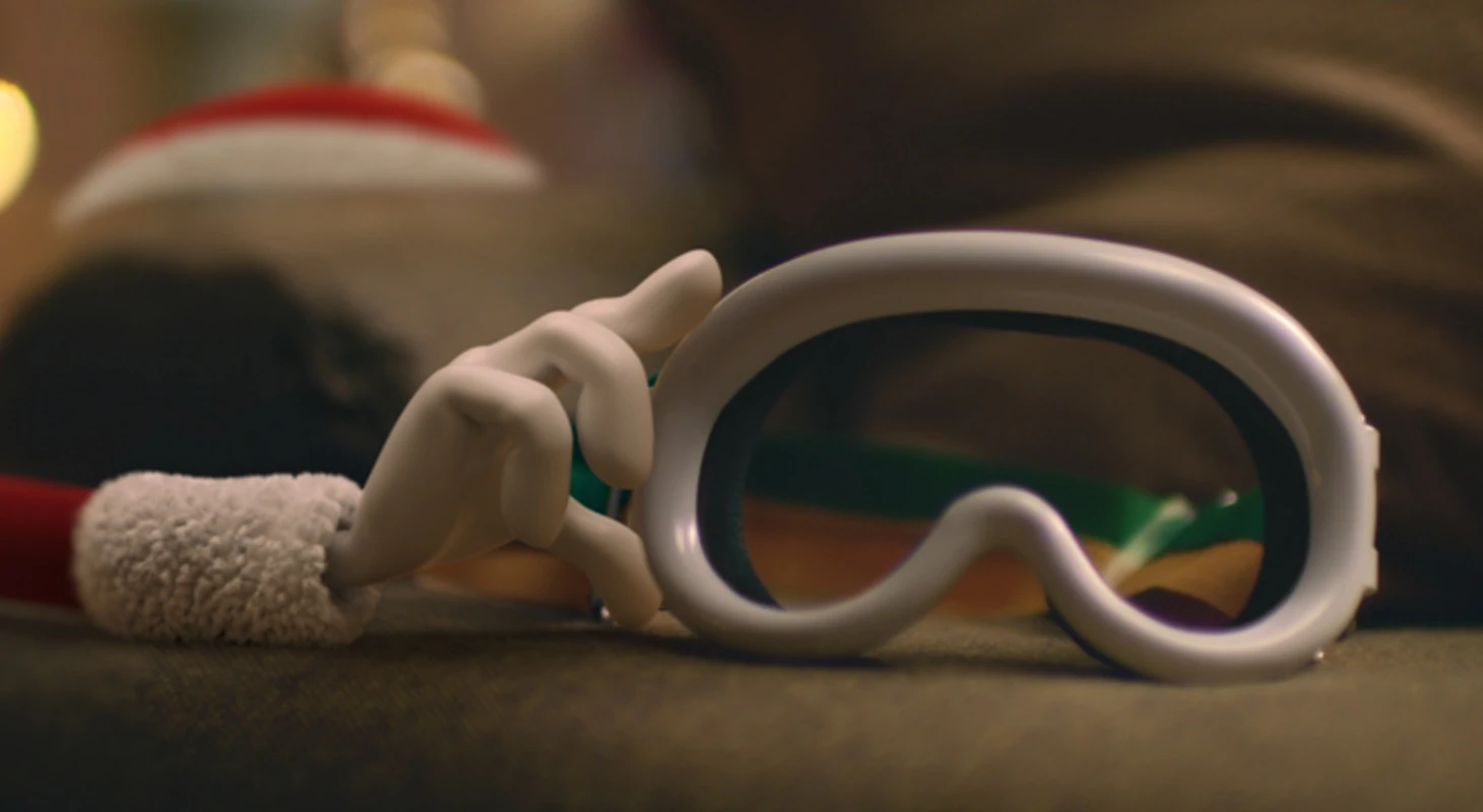 Mão segurando máscara de esqui branca.