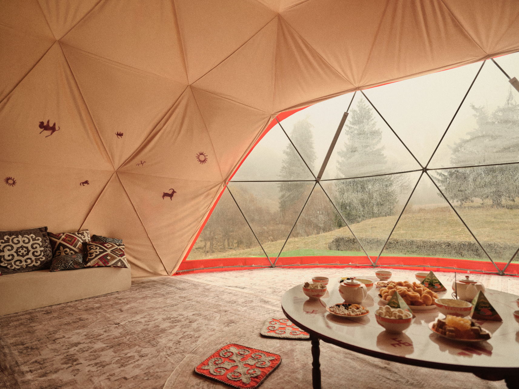 Interior de tenda geodésica com mesa de café da manhã.