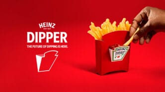 Batata frita sendo mergulhada em ketchup Heinz.
