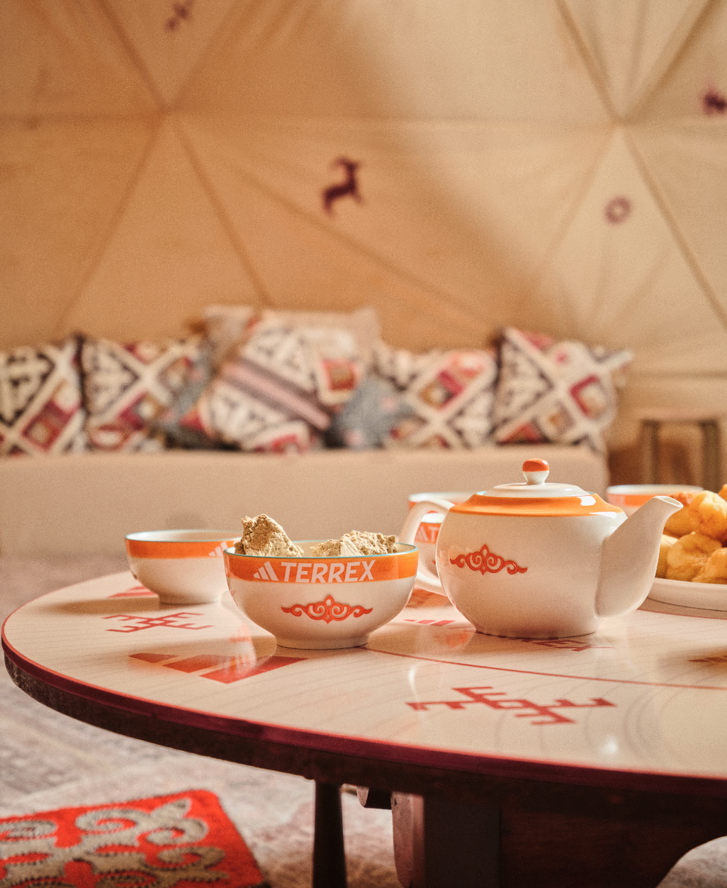 Mesa com chá e decoração colorida em sofá.