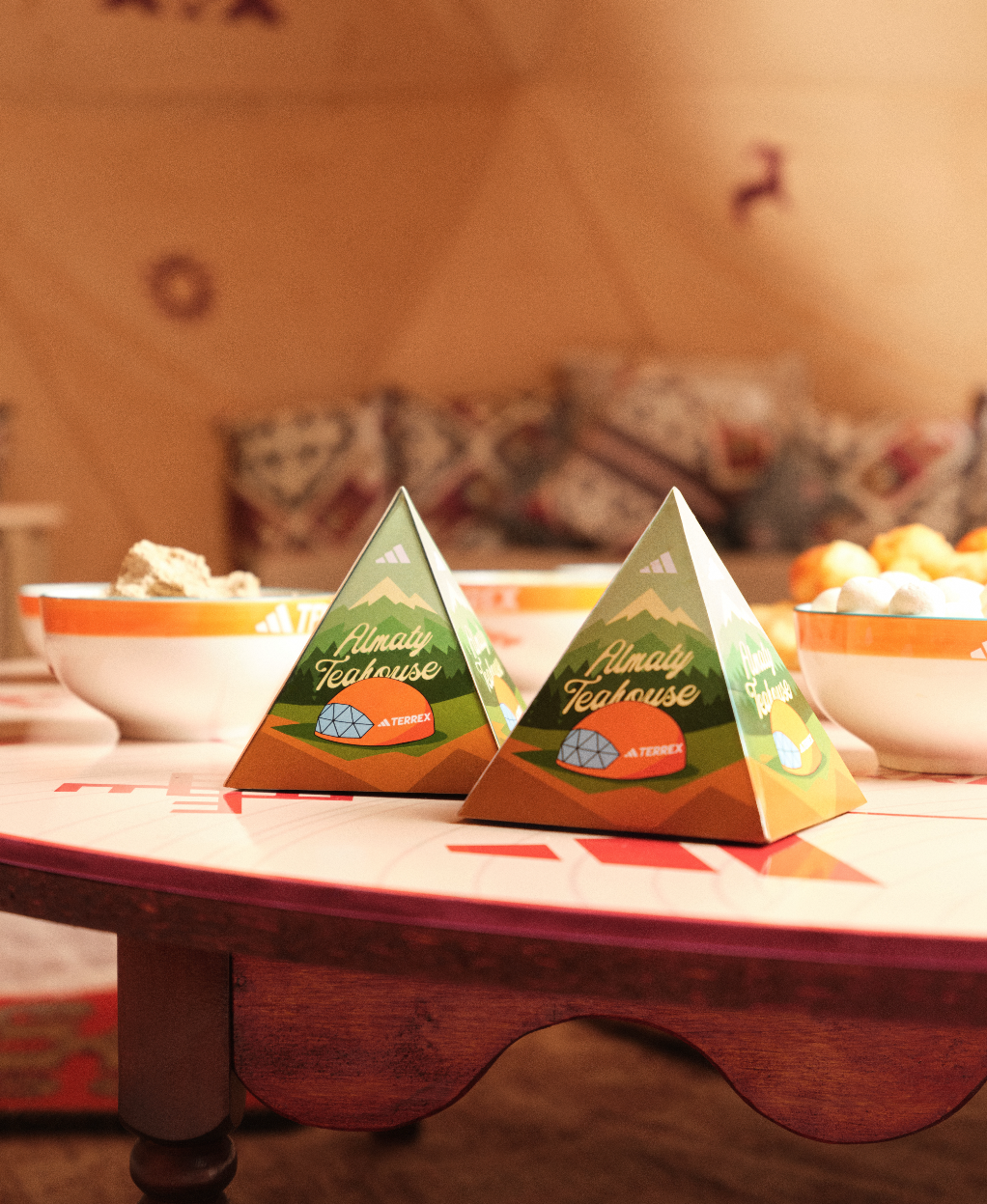 Caixas de chá em mesa com tigelas ao fundo.