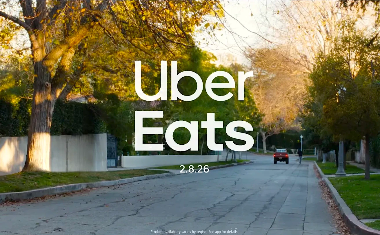 Uber Eats anúncio em rua arborizada.