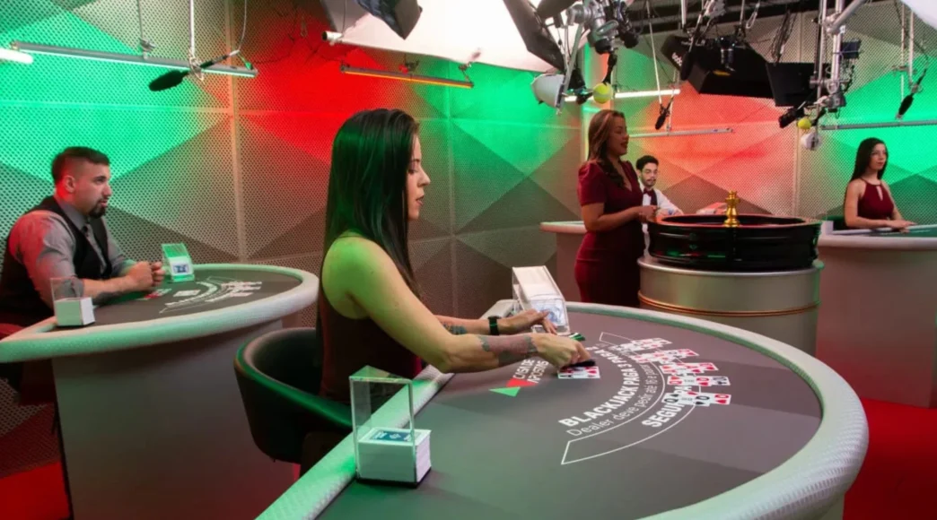Pessoas em mesa de cassino com cartas e roleta.