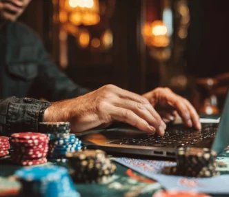 Pessoa usando laptop com fichas de pôquer.