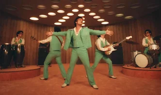 Banda tocando em palco, vestida de verde.