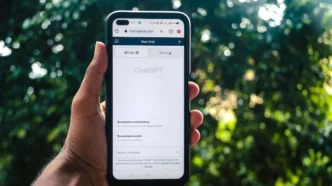 AI-SPM. Smartphone exibindo site ChatGPT em ambiente externo.