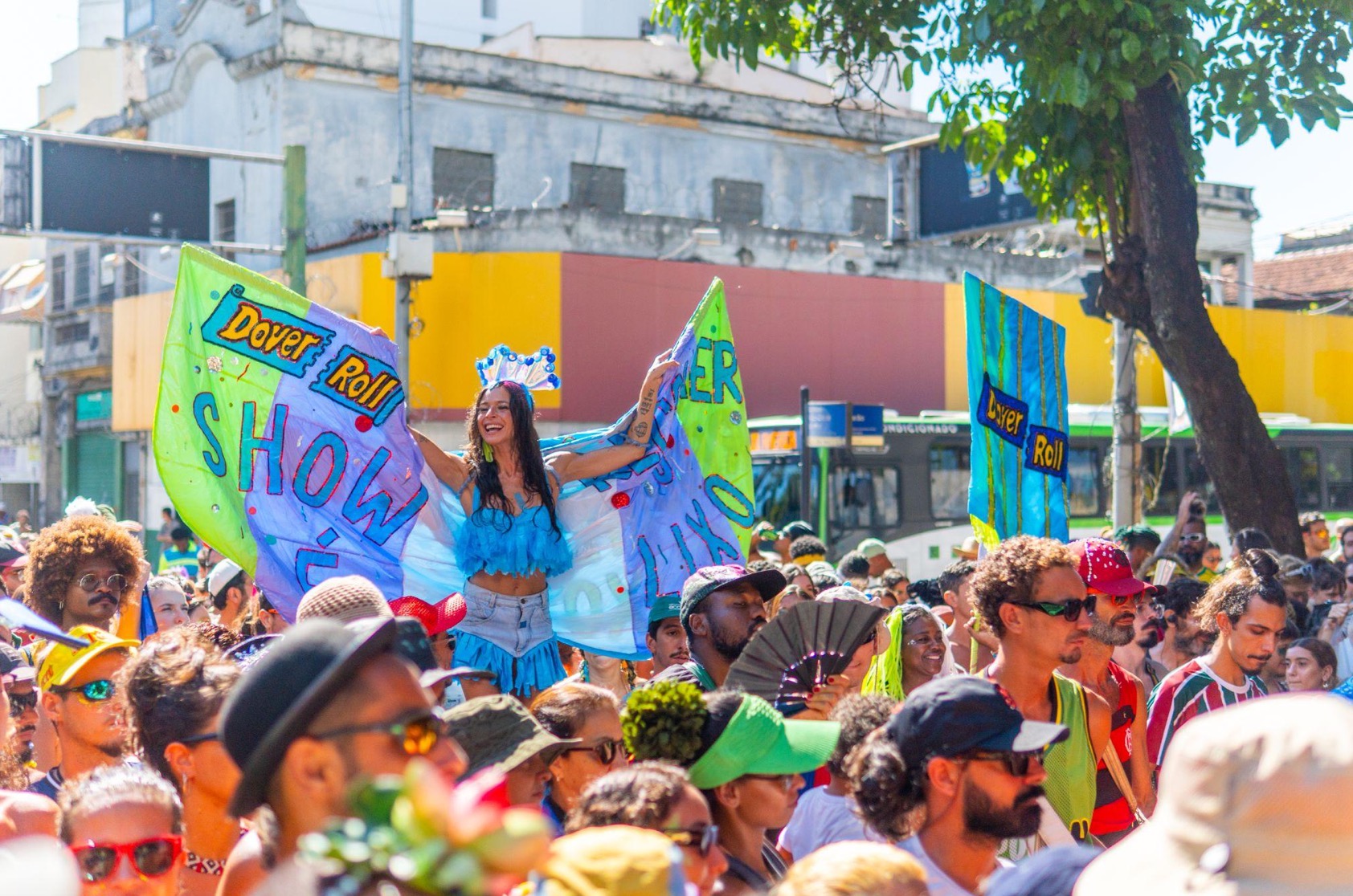 Mulher em festa de carnaval com multidão ao redor.