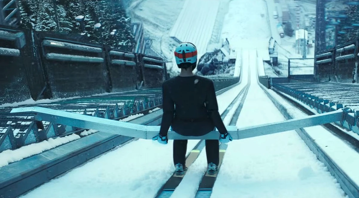 Esquiador pronto para salto em rampa nevada.