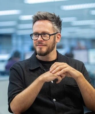 Pessoa de óculos em ambiente de escritório.