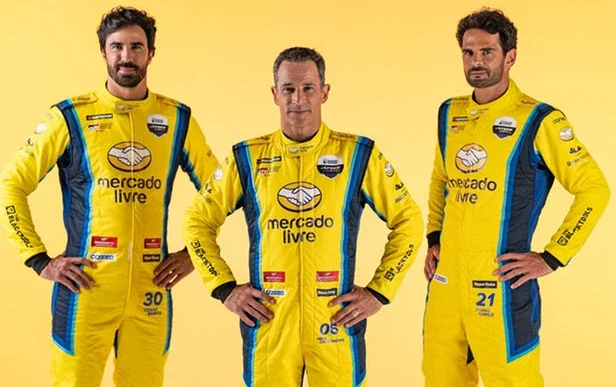Três pilotos em uniformes amarelos do Mercado Livre.