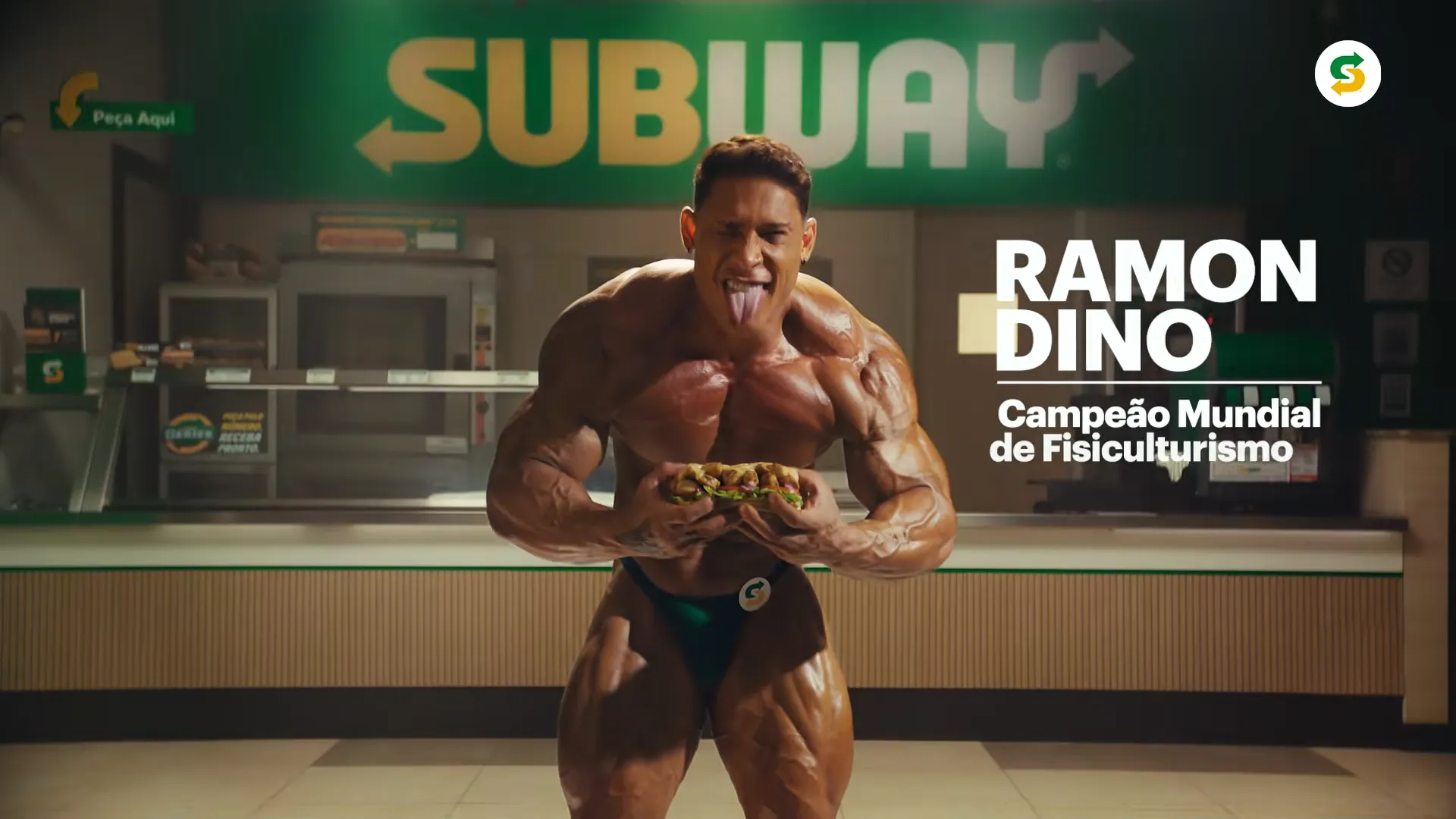 Fisiculturista posando com sanduíche em loja Subway.