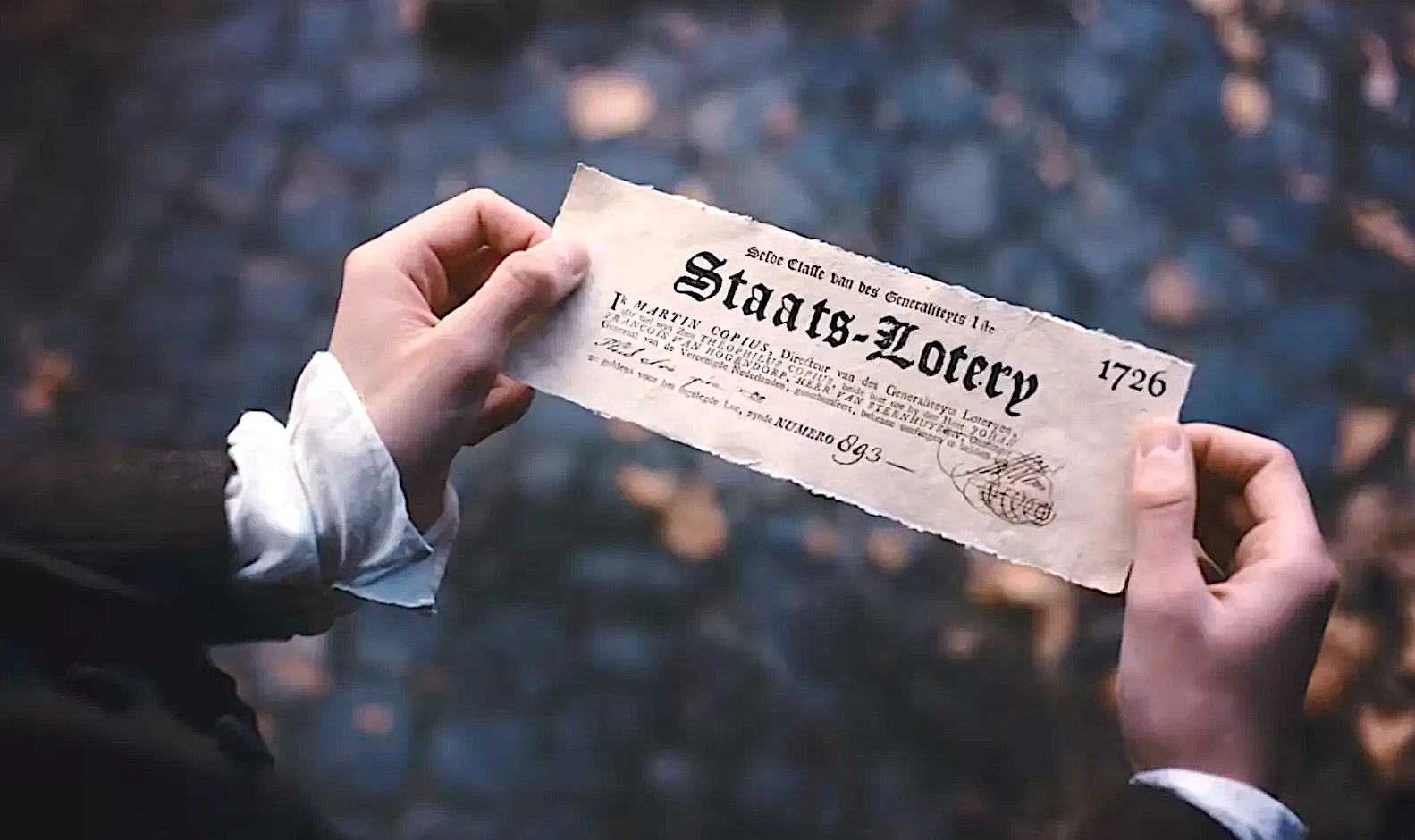 Pessoa segurando bilhete antigo de loteria.