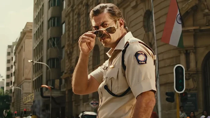 Policial com óculos escuros em rua movimentada.