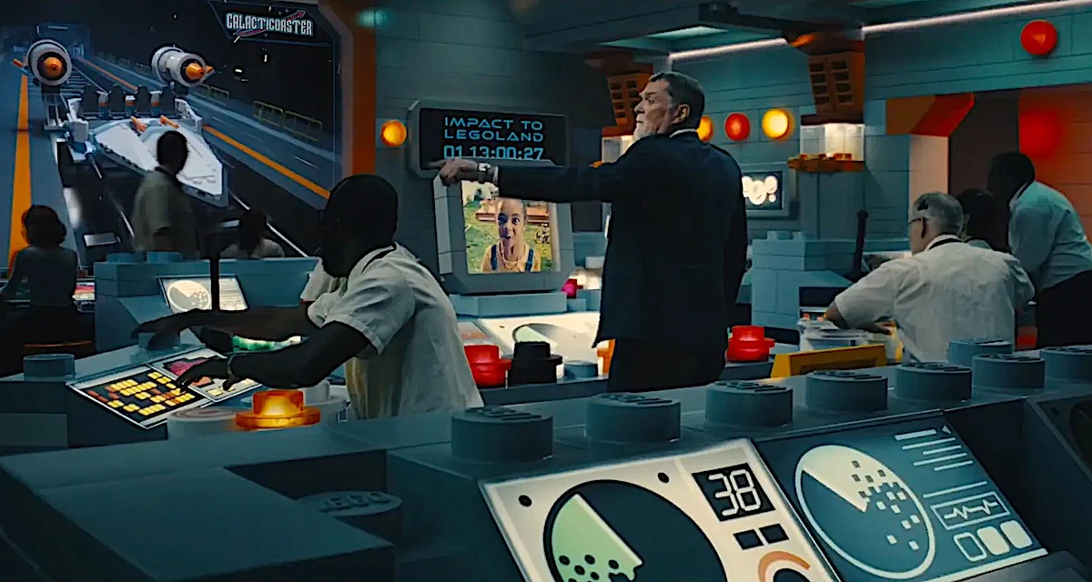 Homem apontando para tela em sala de controle.