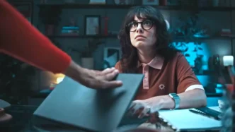 Pessoa com óculos em escritório, olhando para cima.