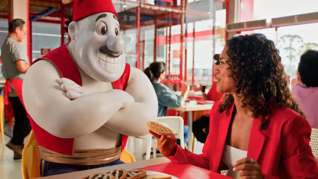 Mulher comindo em restaurante com estátua.