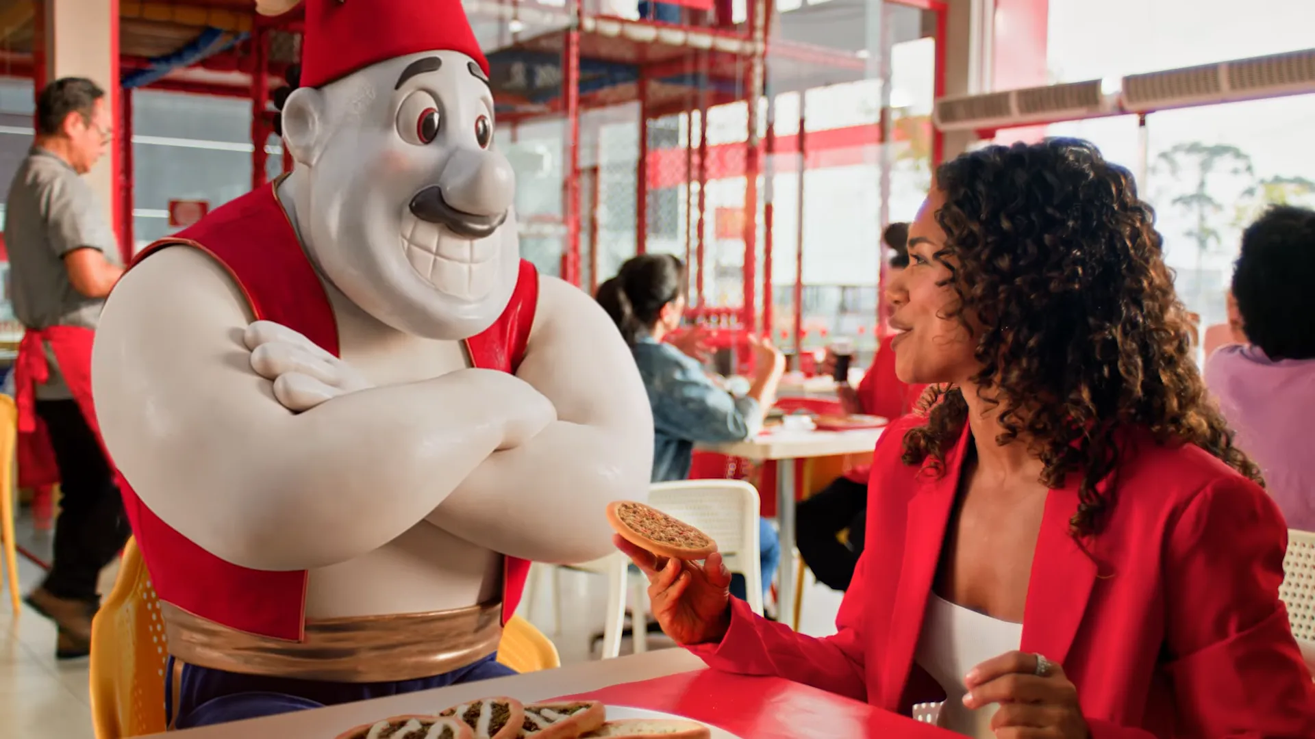 Mulher comindo em restaurante com estátua.