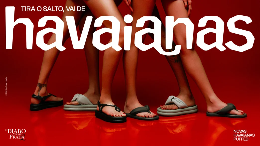Pernas femininas com sandálias Havaianas em fundo vermelho