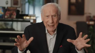 Idoso gesticulando durante entrevista em ambiente interno