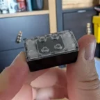 Peça transparente tipo LEGO segurada na mão