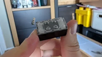 Peça transparente tipo LEGO segurada na mão