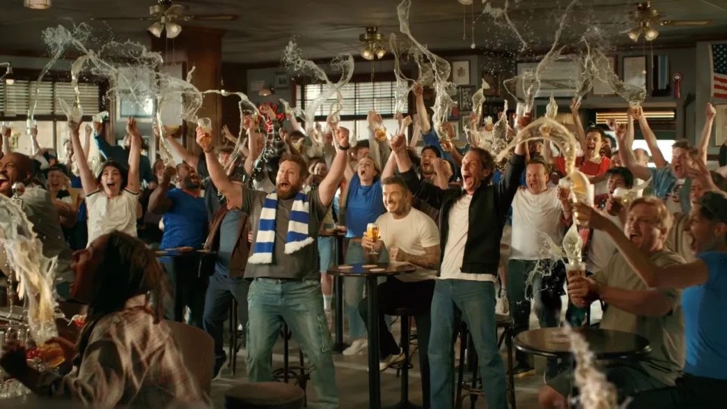 Torcedores comemorando com cerveja em bar lotado