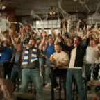 Torcedores comemorando com cerveja em bar lotado