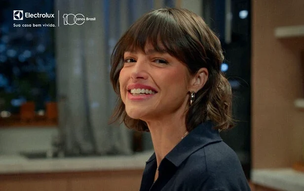 Mulher sorrindo em ambiente interno com logo Electrolux