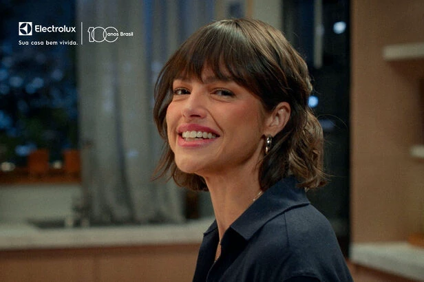 Mulher sorrindo em ambiente interno com logo Electrolux