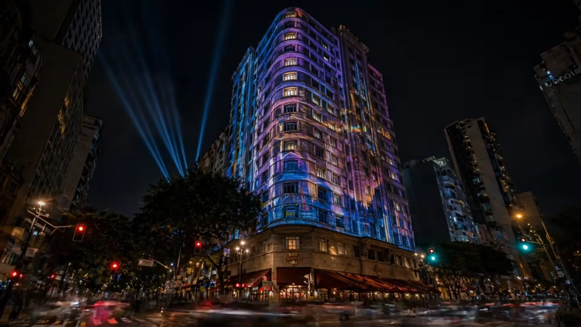 Prédio iluminado com projeções coloridas à noite