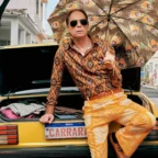 Homem com guarda-chuva estampado sentado em carro amarelo