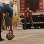 Homem pega bola de futebol na rua