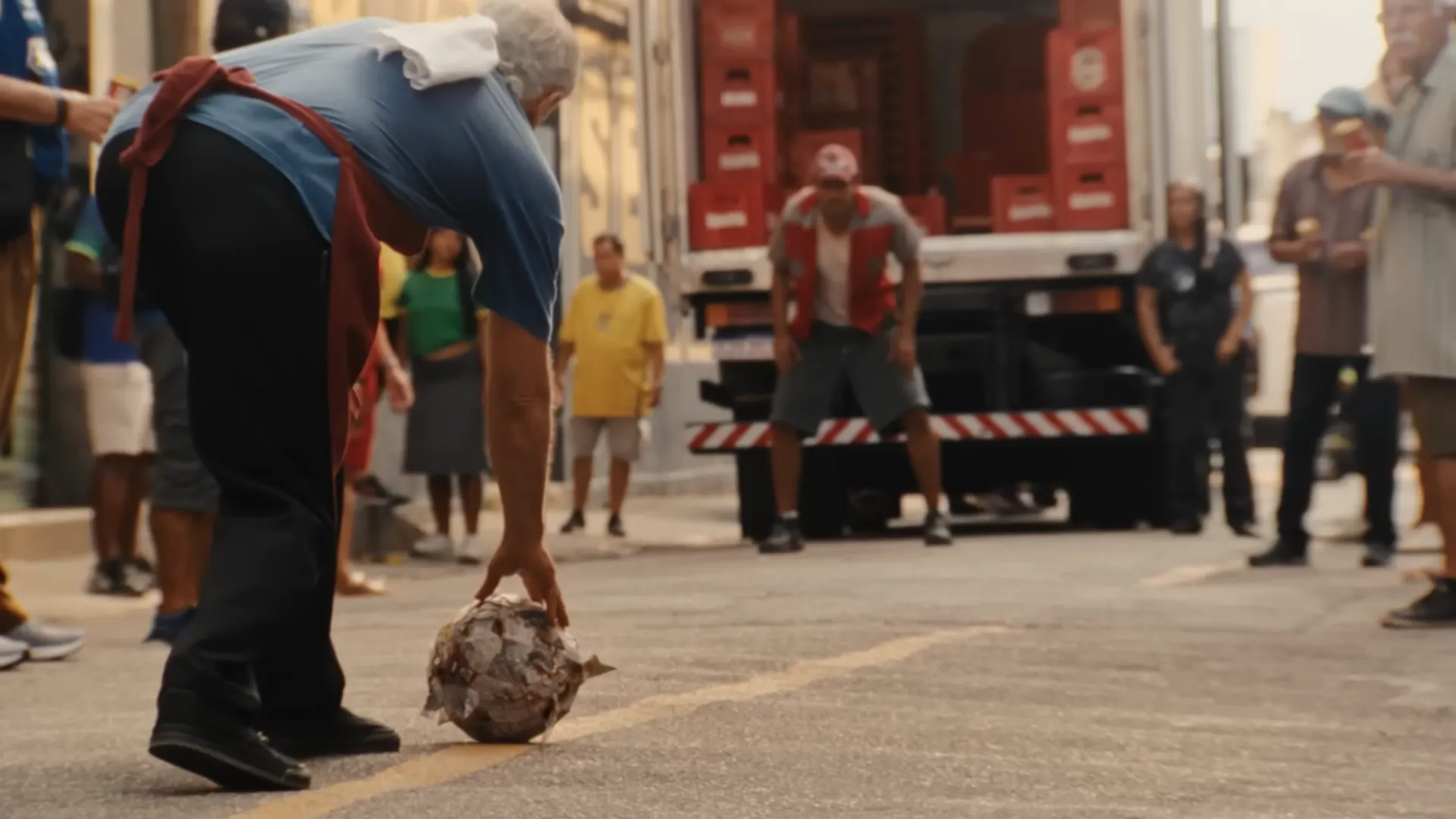 Homem pega bola de futebol na rua